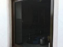 Holzfenster in sepiabraun mit Insektengitter und nach außen öffnend