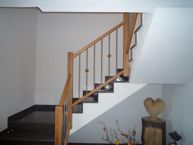 Holztreppe aus Buche mit weißen Setzstufen auf Betontreppe